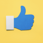 social media like icon in blue on yellow background